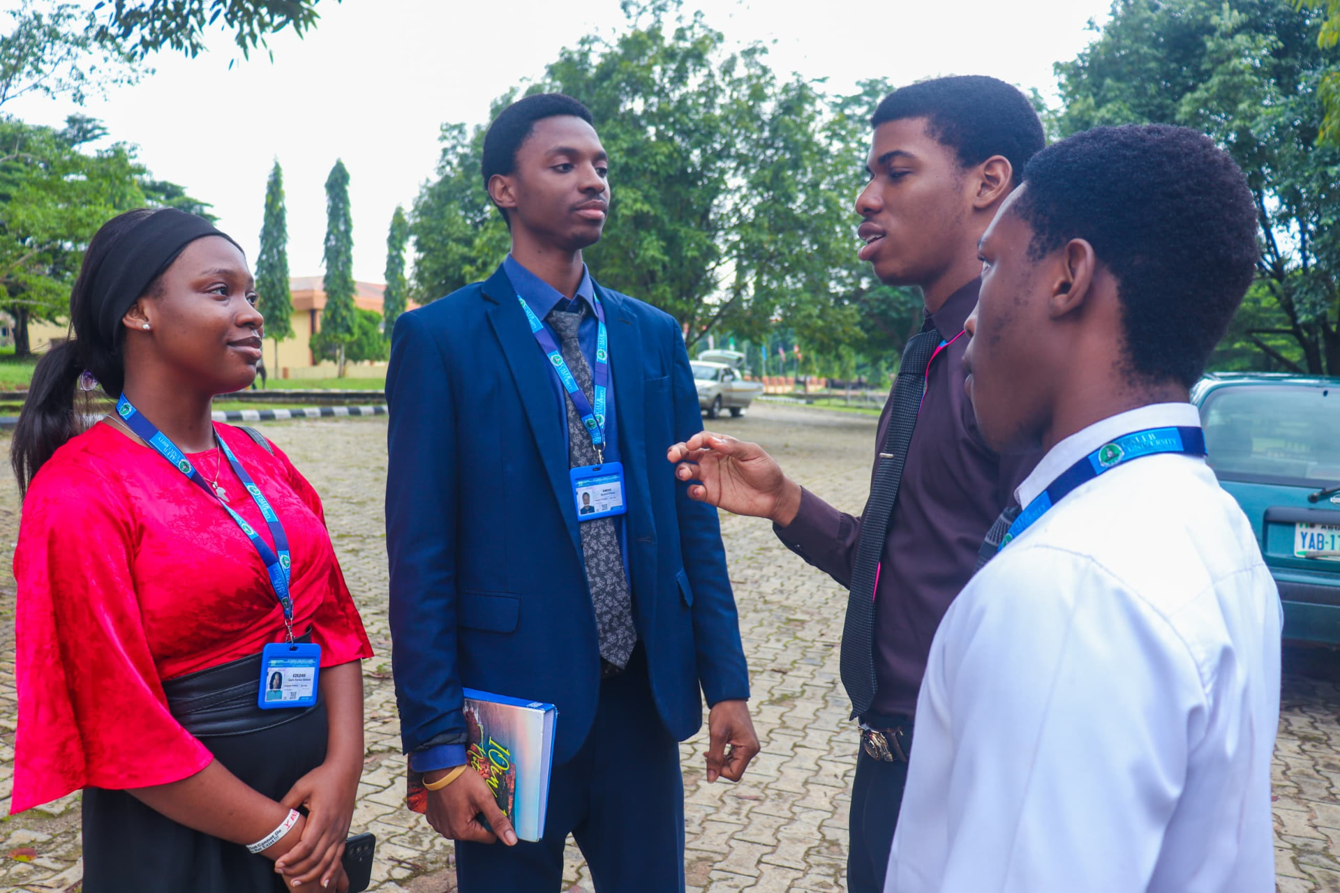 Students in professional dress conversing on the paved campus grounds