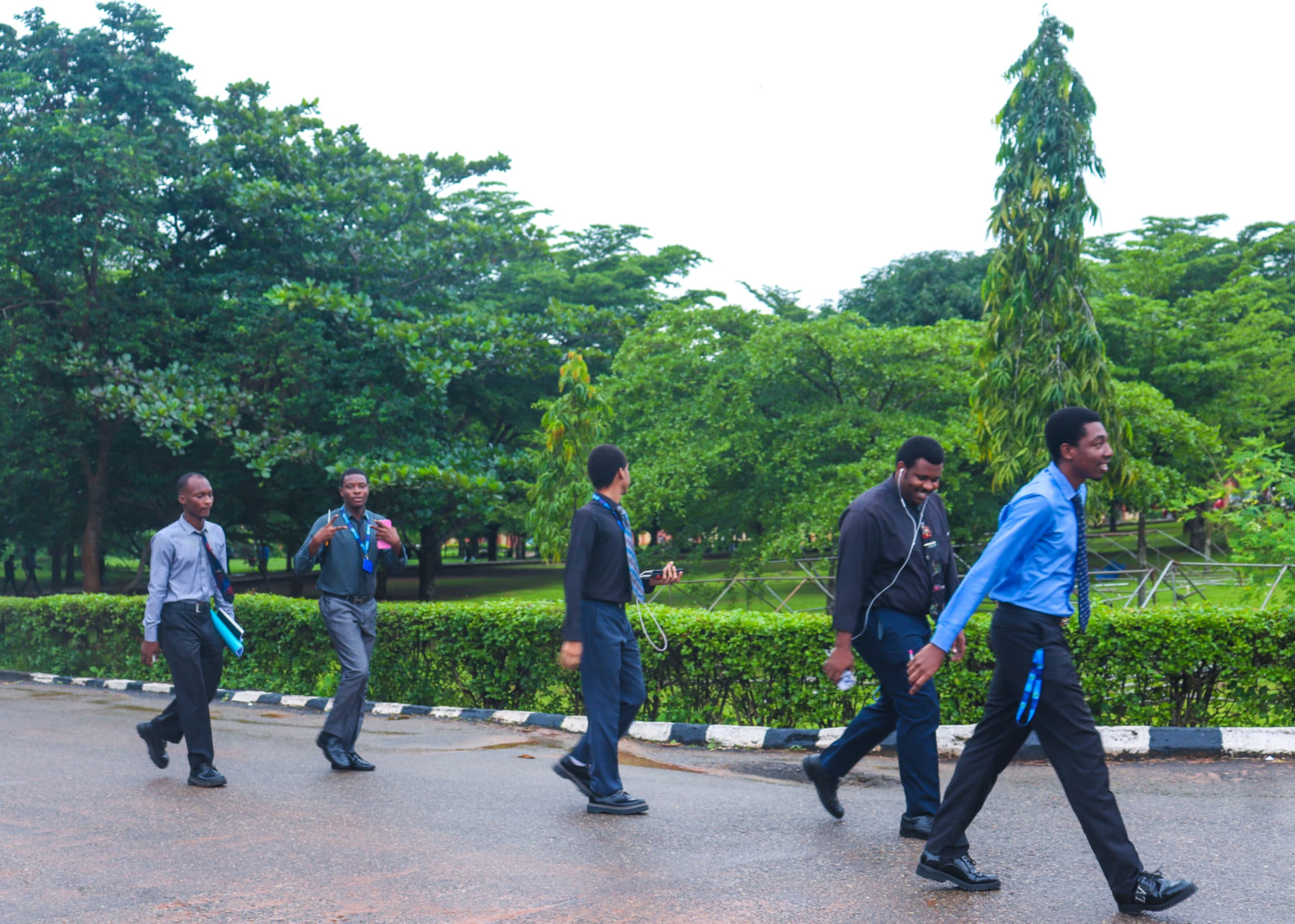 Students in corporate dress walking along a tree-lined campus road